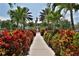 Pathway lined with lush red and green plants, leading to a grand home at 5320 Golden Isles Dr, Apollo Beach, FL 33572