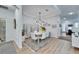 Bright dining room with white table and chairs, stylish light fixture and room divider at 5320 Golden Isles Dr, Apollo Beach, FL 33572