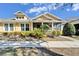 Charming yellow house with front porch and landscaping at 5320 Golden Isles Dr, Apollo Beach, FL 33572