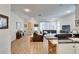 Open living room with grey sofas, wood floors, and a view of the kitchen at 5320 Golden Isles Dr, Apollo Beach, FL 33572