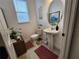 Clean powder room with pedestal sink and decorative mirror at 5508 Viola Lee Way, Lutz, FL 33558