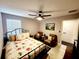 Bedroom with a floral bedspread, two armchairs, and a ceiling fan at 5508 Viola Lee Way, Lutz, FL 33558