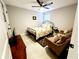 Bedroom with a floral bedspread, two armchairs, and a ceiling fan at 5508 Viola Lee Way, Lutz, FL 33558