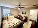 Bedroom with a floral bedspread, two armchairs, and a ceiling fan at 5508 Viola Lee Way, Lutz, FL 33558