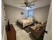 Bedroom with a floral bedspread, two armchairs, and a ceiling fan at 5508 Viola Lee Way, Lutz, FL 33558