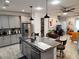 Open kitchen with island, stainless steel appliances, and gray cabinets at 5508 Viola Lee Way, Lutz, FL 33558