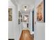 Hallway with hardwood floors, offering views of the kitchen and a gallery wall at 6095 2Nd S Ave, St Petersburg, FL 33707