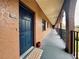 Condo building exterior showing hallway with dark blue front door and arched entryway at 6100 Gulfport S Blvd # 214, Gulfport, FL 33707