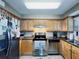 Well-equipped kitchen featuring light wood cabinets, granite counters, and stainless steel appliances at 6100 Gulfport S Blvd # 214, Gulfport, FL 33707