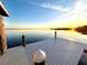White wooden dock extending over calm water at sunset at 724 Bayshore Dr, Terra Ceia, FL 34250