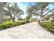 Gravel driveway leads to a charming house with large oak trees at 724 Bayshore Dr, Terra Ceia, FL 34250