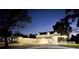 Night view of a charming two-story home with a covered porch and well-lit yard at 724 Bayshore Dr, Terra Ceia, FL 34250