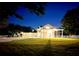 Night view of a spacious farmhouse with a large yard and white fence at 724 Bayshore Dr, Terra Ceia, FL 34250