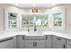 Kitchen features white cabinets, a farmhouse sink, and a view at 724 Bayshore Dr, Terra Ceia, FL 34250