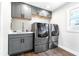 Laundry room with modern washer, dryer, and cabinets at 724 Bayshore Dr, Terra Ceia, FL 34250