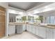 Bright bathroom featuring an expansive vanity with double sinks, granite countertops, and decorative vases at 8701 Ballantrae Way, Tampa, FL 33647