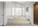 Bright bathroom featuring a soaking tub with glass block windows and a tiled platform at 8701 Ballantrae Way, Tampa, FL 33647