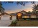 Charming single-story home boasts a well-manicured lawn, three-car garage, and inviting curb appeal at 8701 Ballantrae Way, Tampa, FL 33647
