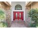 Inviting entryway featuring a striking red double door with decorative glass and brick columns at 8701 Ballantrae Way, Tampa, FL 33647