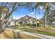 Charming two-story home with lush landscaping, mature trees, and a well-manicured lawn on a sunny day at 8701 Ballantrae Way, Tampa, FL 33647