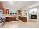 Open kitchen with stainless appliances, dark wood cabinets, and adjacent cozy fireplace area at 8701 Ballantrae Way, Tampa, FL 33647