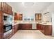 Elegant kitchen with stainless steel appliances, dark wood cabinets, and tile backsplash at 8701 Ballantrae Way, Tampa, FL 33647