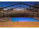 Screened in pool with a hot tub and a brick paved deck during the evening at 8701 Ballantrae Way, Tampa, FL 33647