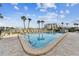 Inviting community pool with lounge chairs and palm trees at 9825 Harrell Ave # 202, Treasure Island, FL 33706