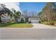 House exterior with a two-car garage and lush landscaping at 10169 Lenox Blvd, Weeki Wachee, FL 34613