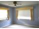 Bedroom with light blue walls, window with blinds and curtains at 1405 Langley Dr # 97, Sun City Center, FL 33573