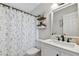 Updated bathroom with white vanity, shower, and floral shower curtain at 19201 Vista Ln # C8, Indian Shores, FL 33785