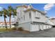 Side view of white two-story condo, showing garage and balcony at 19201 Vista Ln # C8, Indian Shores, FL 33785