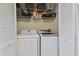 Convenient laundry room with washer, dryer, and shelving at 19201 Vista Ln # C8, Indian Shores, FL 33785