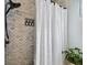 Shower with marble tile and white curtain at 19201 Vista Ln # C8, Indian Shores, FL 33785
