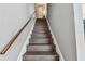Dark hardwood stairs with a simple wooden handrail at 19201 Vista Ln # C8, Indian Shores, FL 33785