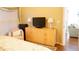 Bedroom with dresser, TV, and view into another room at 2320 Marksmen Ct # 205, Sun City Center, FL 33573