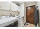 Laundry room with washer, dryer, and overhead cabinets at 25555 Oaks Blvd, Land O Lakes, FL 34639