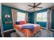 Relaxing bedroom with teal walls, a plush bed, and a ceiling fan at 2709 W Cherry St, Tampa, FL 33607