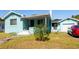 Light teal house with a front porch, steps, and a detached garage at 2709 W Cherry St, Tampa, FL 33607