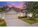 Beige house with a two-car garage and landscaping at 2737 Valencia Grove Dr, Valrico, FL 33596