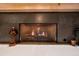 Modern gas fireplace with stone surround and mantel at 28559 Marsciano Ln, Wesley Chapel, FL 33543