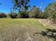 Large grassy front yard with mature trees at 3447 Loveland Blvd, Port Charlotte, FL 33980