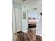 View of bedroom from hallway; features light walls, wood flooring and a ceiling fan at 3628 Dellefield St, New Port Richey, FL 34655