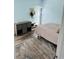 Bedroom with light blue walls, wood-look flooring, and a round rug at 3628 Dellefield St, New Port Richey, FL 34655