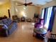 Bright living room featuring hardwood floors, comfy seating, and a ceiling fan at 37733 Dunbar Ave, Zephyrhills, FL 33542