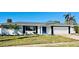 Newly renovated home with white brick exterior, gray roof, and a blue front door at 3946 Doral Dr, Tampa, FL 33634