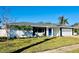 Newly renovated home with white brick exterior, gray roof, and a blue front door at 3946 Doral Dr, Tampa, FL 33634