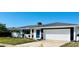 Newly renovated home with white brick exterior, gray roof, and a blue front door at 3946 Doral Dr, Tampa, FL 33634