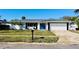 Newly renovated home with white brick exterior, gray roof, and a blue front door at 3946 Doral Dr, Tampa, FL 33634