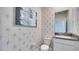 Stylish powder room with patterned wallpaper and granite vanity at 4318 Pullet Ct, Lakewood Ranch, FL 34211